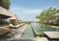 an infinity pool at a resort with chairs and tables at Qunci Villas Resort in Senggigi