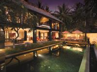 a villa with a swimming pool at night at Qunci Villas Resort in Senggigi