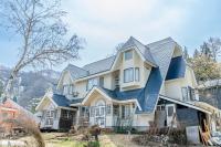 a large house with a blue roof at Pension Bonnard in Hakuba