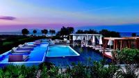 Una piscina con tumbonas y un resort. en Mare Nostrum Santo, en Oia