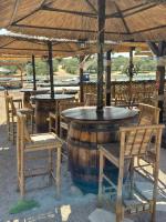un groupe de tables et de chaises sous un parapluie dans l'établissement Relaxing Mobile Home Maestral - Beach, Private Jacuzzi, Pool Access, à Drage