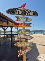 un panneau sur la plage avec de nombreux panneaux différents dans l'établissement Relaxing Mobile Home Maestral - Beach, Private Jacuzzi, Pool Access, à Drage