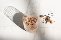 Una taza de café sobre un mostrador blanco con granos de café. en ZEM Wellness Clinic Altea - 5 Stars Grand Luxury, en Altea