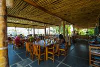 Un comedor con mesa y sillas de madera. en Mucumbli, en Ponta Figo