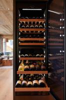 un estante de vino lleno de muchas botellas de vino en Fender Chalets Sonnalm Luxury Homes, en Gmünd in Kärnten