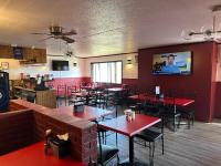 un ristorante con tavoli e sedie rossi e una TV a parete di Travelodge by Wyndam Chetwynd a Chetwynd