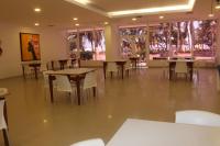 a dining room with tables and chairs and windows at Hotel Dorado Plaza Bocagrande - All Inclusive in Cartagena de Indias