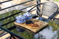 a plate of food on a table with blue and white vases at Dunhuang County Posthouse in Dunhuang