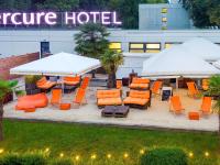 ビーレフェルトにあるMercure Hotel Bielefeld Johannisbergのホテル正面の屋外パティオ(椅子、パラソル付)
