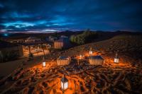 Un grupo de mesas en el desierto por la noche. en Camp Under Stars, en Merzouga