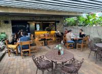 un grupo de personas sentadas en mesas en un restaurante en Candelaria Aparta Hotel Boutique, en Medellín