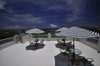 a patio with tables and chairs and umbrellas at Yurong B&amp;B in Magong
