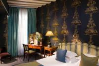 a bedroom with a bed and a desk with a mirror at Hotel Residence Des Arts in Paris