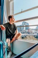 a man sitting on a ledge looking out a window at Eden Quay Guesthouse Private Rooms in Dublin