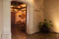 Un arco que conduce a un comedor con una mesa. en Casa del Alma Hotel Boutique & Spa, en San Cristóbal de Las Casas