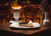 a piece of cake on a plate next to a drink at Hotel Boutique Casa Madero in Morelia