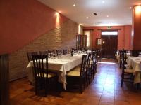 ein Esszimmer mit Tischen und Stühlen und einer Ziegelwand in der Unterkunft Hotel Rural Carlos I in Garganta la Olla