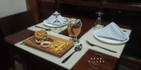 a table with a sandwich and french fries and a glass of wine at Rue DeuxVilles Villa in Loon