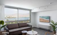 ein Wohnzimmer mit Couch und großem Fenster in der Unterkunft Luxury Apartments And Studios At Sea Side By Rently in Eilat