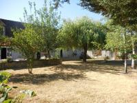 a yard with trees in front of a house at Les rouches in Cormeray