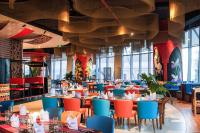 Un comedor con mesas y sillas y ventanas. en LYN Premier Studio Panorama Nha Trang, en Nha Trang