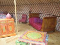 a room with a bed and a table in a yurt at Le Mas Nomade in Callian