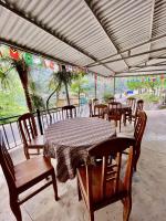 a table and chairs under a roof with a table at Chin Chin House Trekking & Homestay in Sa Pa