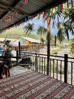 a patio with a fence and a palm tree and flags at Chin Chin House Trekking & Homestay in Sa Pa