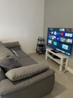 Televízia a/alebo spoločenská miestnosť v ubytovaní Les appartements d’Edgar