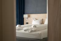 Un dormitorio con una cama con sábanas y almohadas blancas. en BREEZE Hotel Victoria - Self-Service, en Bergen