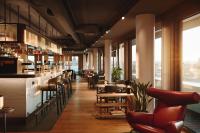 ein Restaurant mit Bar sowie Tischen und Stühlen in der Unterkunft A by Adina Vienna Danube in Wien