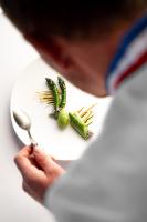 una persona sosteniendo una cuchara y algunas verduras en un plato en La Chèvre d'Or, en Èze