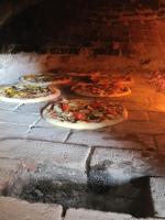um grupo de pizzas num forno de tijolos em Hotel Timun em Gdinj