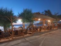 um restaurante com pessoas sentadas em uma cerca de madeira em Hotel Timun em Gdinj