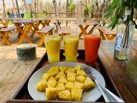 Una bandeja con un plato de comida sobre una mesa con bebidas. en Breezy Beach Cabanas, en Arugam Bay