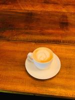 una taza de café en un plato sobre una mesa en Breezy Beach Cabanas, en Arugam Bay