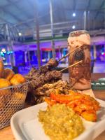 Una mesa con un plato de comida y una bebida. en MERAKI BEACH RESORT Lodges, en Lomé