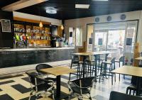 Un restaurante con mesas y sillas y un bar. en Hôtel L'Acropole, en Nissan-lez-Enserune