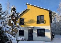 ein gelb-weißes Haus im Schnee in der Unterkunft Ferienpark Rübezahl am Müggelsee, Haus 21 Efeu mit eigener Sauna, idealer Ort für Natur- und Erholungssuchende, für Radfahrer, Familien mit Kindern und Hundeliebhaber in Berlin