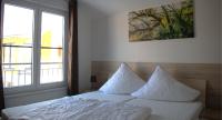 ein Schlafzimmer mit einem Bett mit weißen Laken und Kissen in der Unterkunft Ferienpark Rübezahl am Müggelsee, Haus 21 Efeu mit eigener Sauna, idealer Ort für Natur- und Erholungssuchende, für Radfahrer, Familien mit Kindern und Hundeliebhaber in Berlin