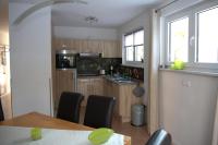 eine Küche mit Tisch und Stühlen in einem Zimmer in der Unterkunft Ferienpark Rübezahl am Müggelsee, Haus 20 Mohn mit eigener Sauna, idealer Ort für Natur- und Erholungssuchende, für Radfahrer und Familien mit Kindern in Berlin