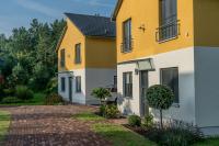 ein gelbes und weißes Haus mit Auffahrt in der Unterkunft Ferienpark Rübezahl am Müggelsee, Haus 20 Mohn mit eigener Sauna, idealer Ort für Natur- und Erholungssuchende, für Radfahrer und Familien mit Kindern in Berlin