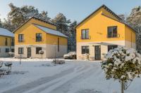 eine Reihe gelber Häuser im Schnee in der Unterkunft Ferienpark Rübezahl am Müggelsee, Haus 20 Mohn mit eigener Sauna, idealer Ort für Natur- und Erholungssuchende, für Radfahrer und Familien mit Kindern in Berlin