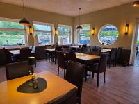 une salle à manger avec tables, chaises et fenêtres dans l'établissement Hotel Seeblick am Sankelmarker See - Natur und Erholung, à Oeversee
