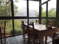 a dining room with a table and chairs and windows at yagour hebergement in Setti Fatma