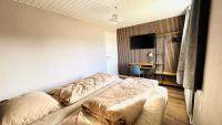 ein Schlafzimmer mit einem Bett, einem Schreibtisch und einem Fernseher in der Unterkunft Guest Home Oksbøl in Oksbøl