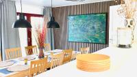 ein Esszimmer mit Tisch und Stühlen und einem Gemälde in der Unterkunft Guest Home Oksbøl in Oksbøl