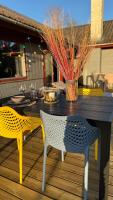 ein Tisch mit zwei Stühlen und einer Vase auf einem Deck in der Unterkunft Guest Home Oksbøl in Oksbøl