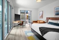 サンディエゴにあるSentral Gaslamp Quarterのベッドと机があるホテルの部屋