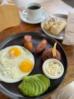 Eco Suites El Zonte في لا ليبرتاد: طبق من طعام الإفطار مع نقانق البيض والخبز